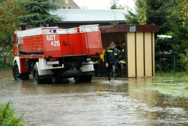 Ochotnicy na przystanku papierosy palą. Na worki czekają