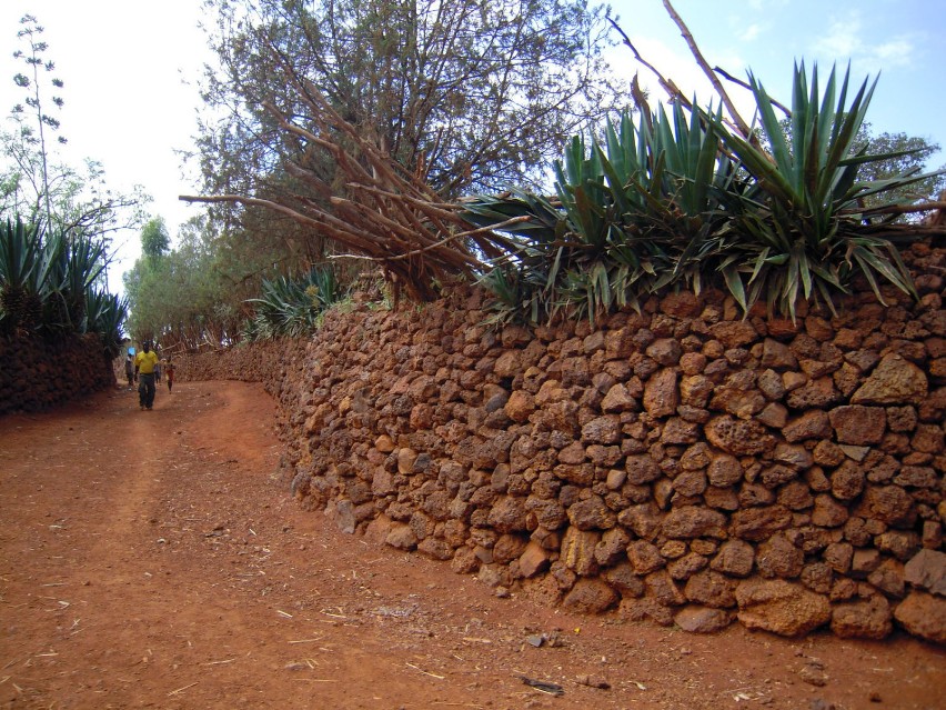 Droga prowadząca do wioski. Kamienny mur otaczający wioskę....