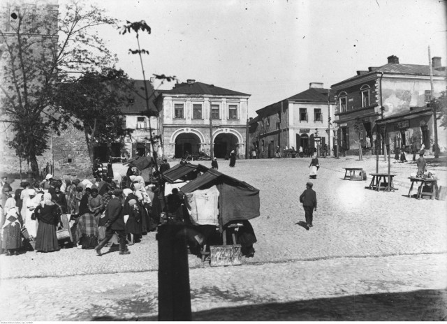 Fragment rynku w Sandomierzu z widocznymi straganami. Na wprost kamienica Oleśnickich z charakterystycznymi podcieniami. Lata 30. XX wieku.