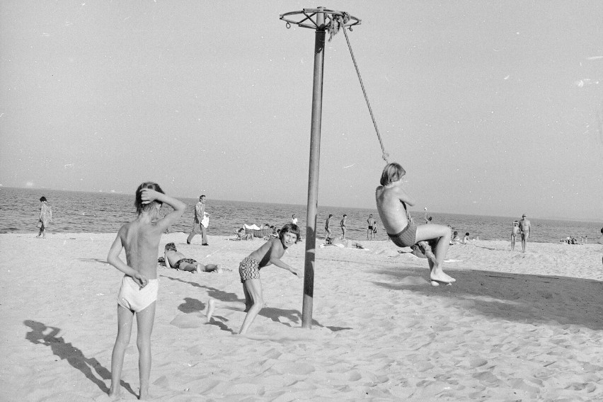 Chłopcy podczas zabawy na plaży w Sopocie. W oddali widać...