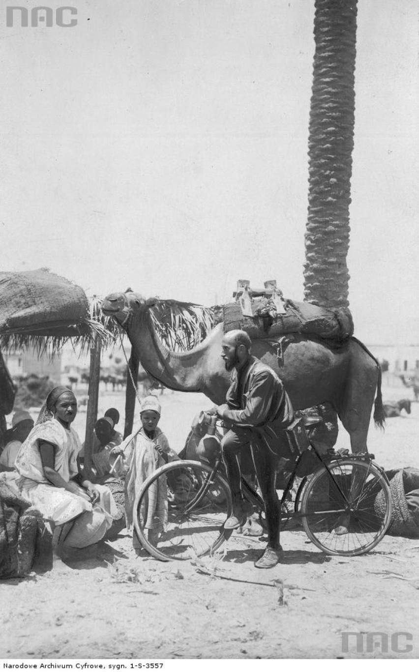 Kazimierz Nowak oparty o rower w rozmowie z arabską rodziną w Trypolitanii. 1931/12, Trypolitania (włoska kolonia)