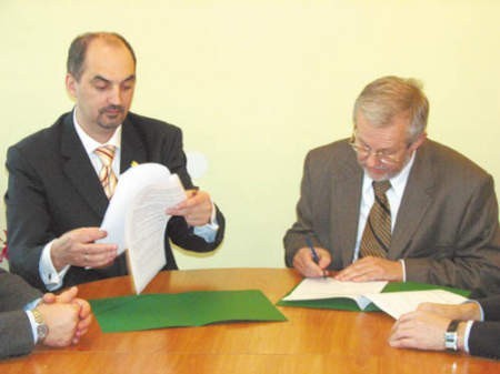 Paweł Silbert i Florian Kuźnik składają podpisy pod umową o wzajemnej współpracy.