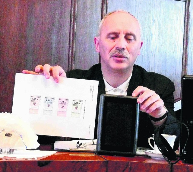 Stanisław Smoliński z ratusza pokazuje nowy wzór biletów papierowych i kasownik do elektronicznych biletów