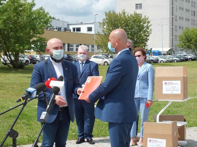 Grzegorz Kaleta, dyrektor starachowickiego szpitala, odbiera dokumenty na respiratory od księdza Damiana Drabikowskiego, wicedyrektora „Caritas” Diecezji Radomskiej.