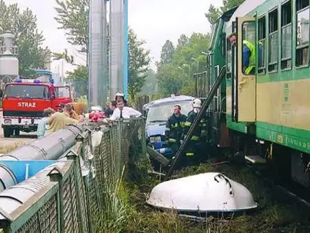 Miejsce wypadku - zmiażdżony VW bus zaklinował się między pociągiem a ogrodzeniem portu. Z samochodu strażacy wyciągnęli rannych i ofiarę tragedii.
Fot. Krzysztof Miśdzioł