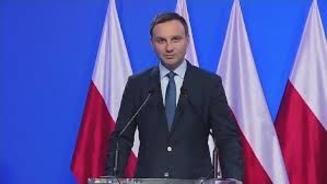 Prezydent Duda na tle sztandarów