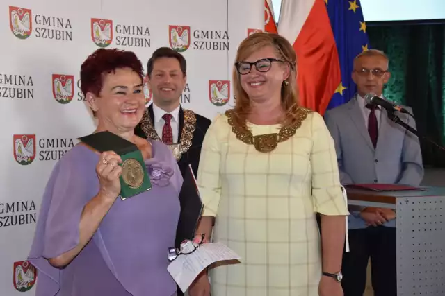 Medal  prezentuje Irena Hałas. Obok Anna Kijowska, przewodnicząca Rady Miejskiej Szubina. Z tyłu burmistrz Mariusz Piotrkowski