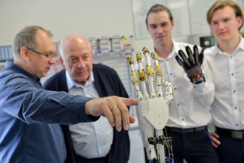 Prof. Mirosław Szmajda (z lewej) pokazuje cyber-dłoń. Obok...