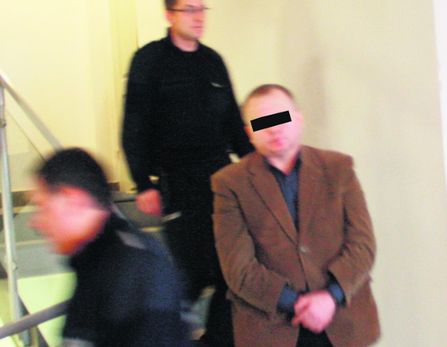 Oskarżony Janusz S. w konwoju idzie na salę rozpraw