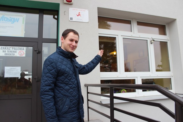Ks. Paweł Filipiak pokazuje sensor zamontowany na budynku Szkoły Podstawowej nr 6 w Chrzanowie