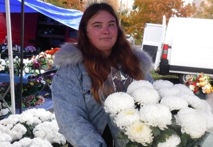 Sprzedawcy na targowisku oferują wiązanki i kwiaty na groby.