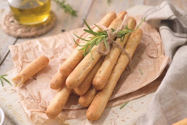 Włoskie grissini to chlebowe paluchy o kształcie patyków. Najczęściej podaje się je w ramach przystawki.