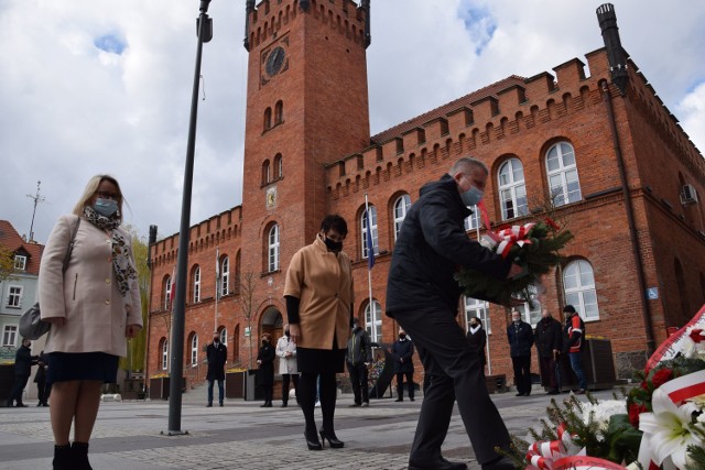 Składanie kwiatów pod tablicą na placu Wolności w Szczecinku