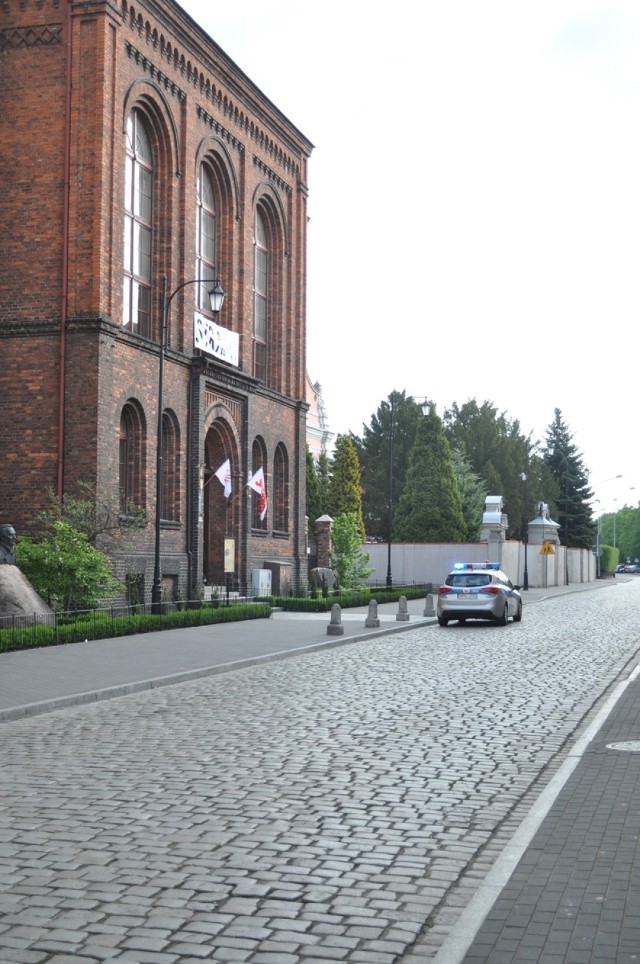 Maturzyści z LO w Śremie mierzą się z egzaminem z matematyki. W tle policja przeszukująca szkoły