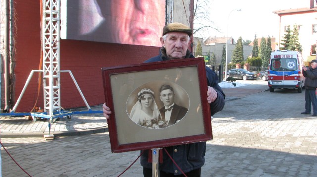 Henryk Janoszka ze Zbrosławic podczas otwarcia muzeum w Radzionkowie. Jego ojciec został deportowany. Trzyma zdjęcie ślubne swoich rodziców.