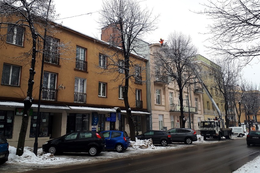 Służby porządkowe usuwają zalegający na dachach śnieg oraz...