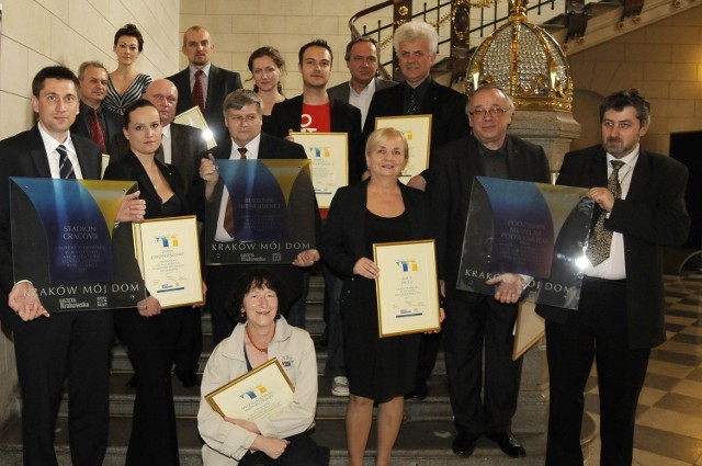 Wspólne zdjęcie laureatów konkursu &quot;Kraków mój dom&quot; z dyplomami i nagrodami