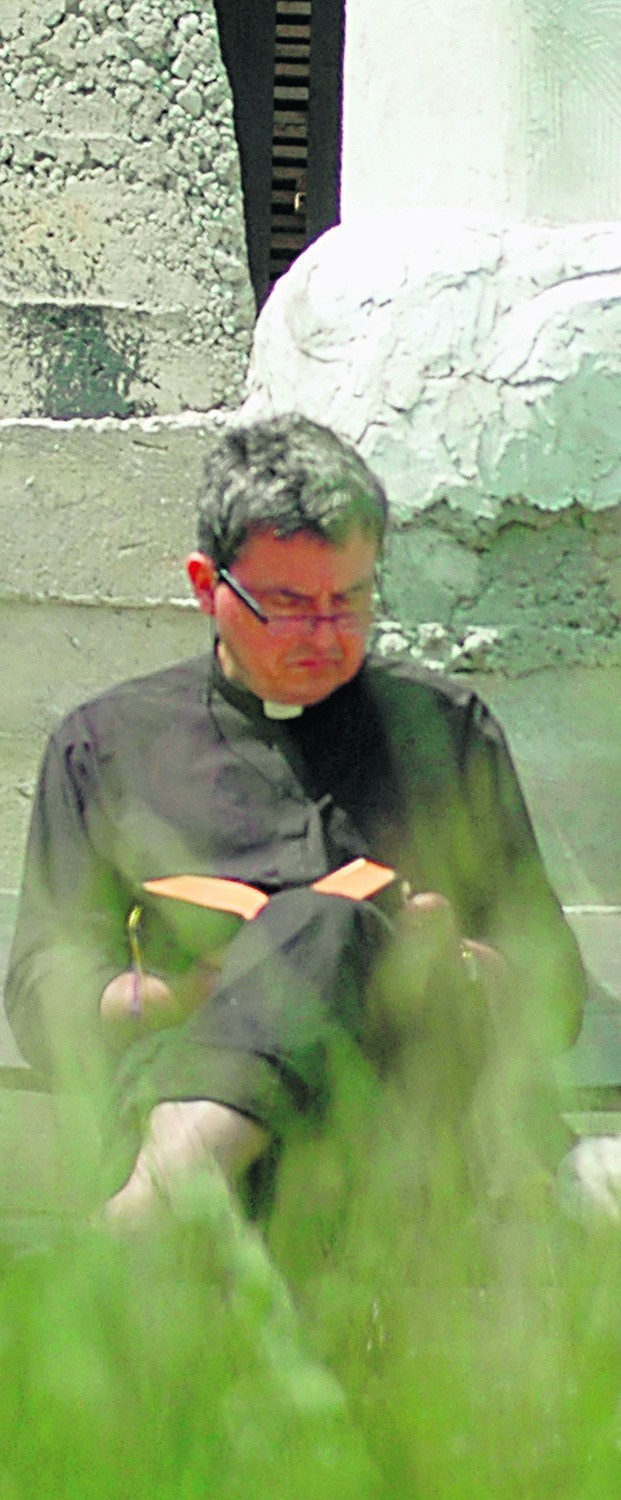 Ks. Piotr Natanek czyta Pismo św. w swojej pustelni, u stóp...