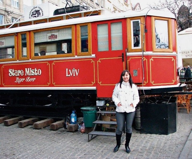 Ala Surmyk z Ukrainy na tle tramwaju-kawiarenki, który stoi we Lwowie