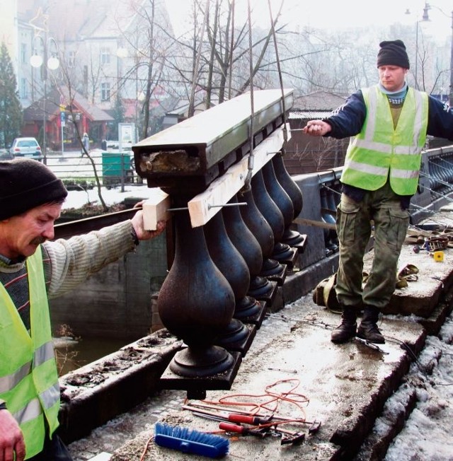 Budowlańcy rozbierają jedną z balustrad zabytkowego mostu