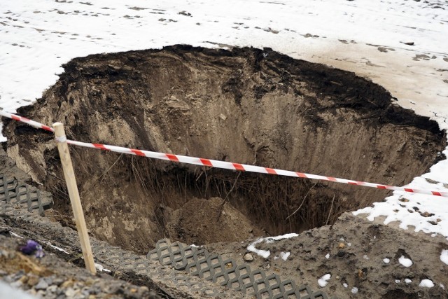 Zapadlisko w Bolesławiu 15.02.2023. Zapadła się ziemia przy obwodnicy. Drogą mogą jechać samochody poniżej 7 ton