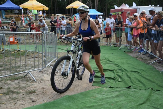 Ludzie z żelaza - tak określa się zawodników, którzy startują w triathlonie. Taki przez ten weekend odbywał się nad jeziorem Reczynek w Ośnie Lub., gdzie start i metę usytuowano przy amfiteatrze. W sobotę triathloniści brali udział w zawodach rozgrywanych na dwóch dystansach: 1/8 Iron Mana (475 m pływania, 22,5 km jazdy na rowerze, 5,25 km biegu) oraz 1/4 Iron Mana (950 m pływania, 45 km jazdy na rowerze, 10,55 km biegu). Za to na niedzielę zaplanowano crosstriahtlon (300 m pływania, 11 km jazdy na rowerach, nie po mieście, a po lesie i 2,5 km biegu) sztafetę rodzinną/drużynową W 1/4 IM pierwszy był Wojciech Greguła, 1/8 Adrian Klincewicz. Zobacz, jak dopingowali kibice w niedzielę na crosstriathlonie.

