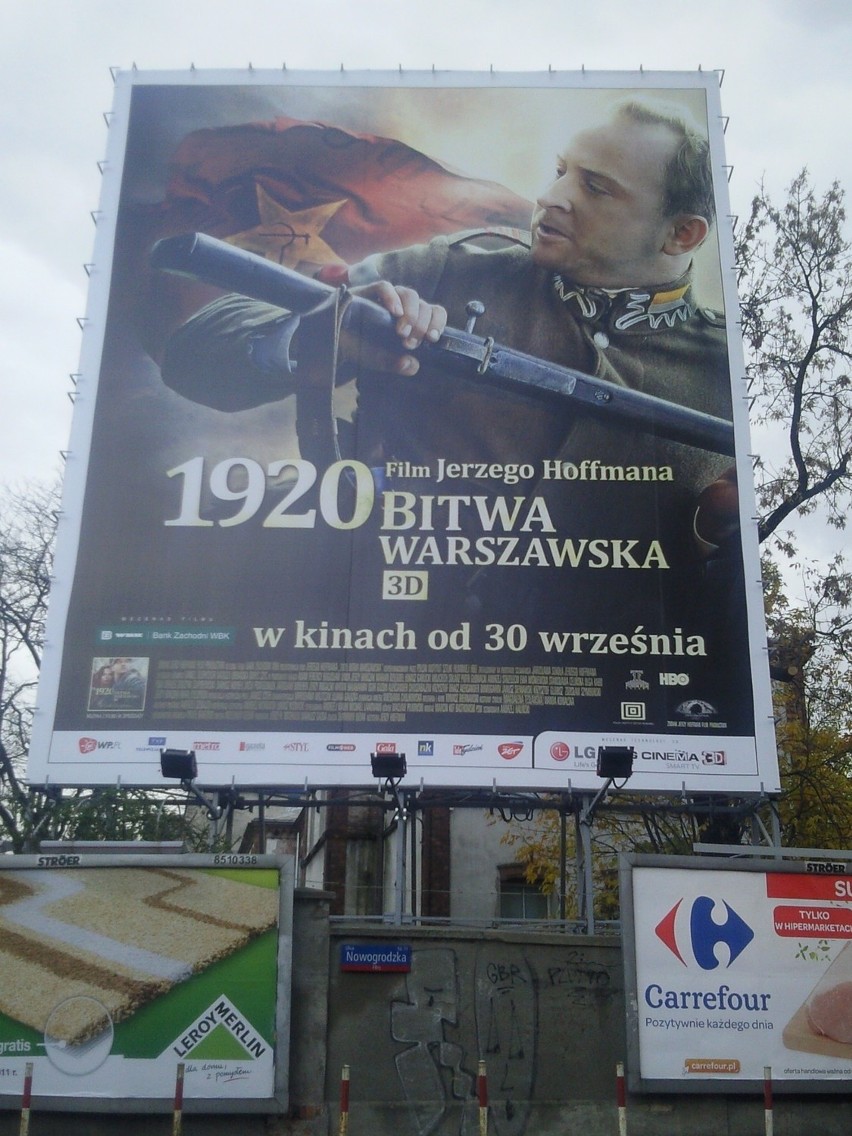 Nielegalny baner reklamowy na zabytkowym murze szpitala Dzieciątka Jezus