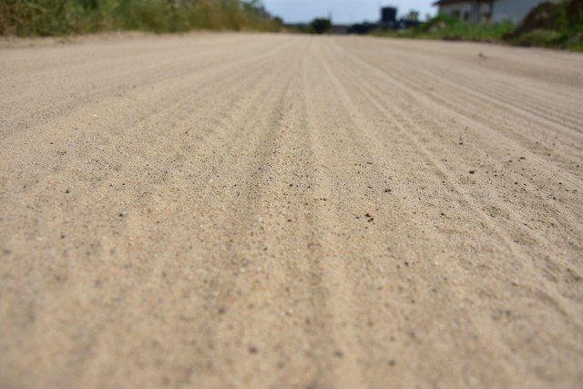 Na części nienazwanej jeszcze uliczce łączącej ul. 1 Stycznia i Dąbrowskiego w Żninie nawierzchnia przypomina piasek na plaży. jak przejeżdżają auta, z drogi unosi się kurz. - To nie do wytrzymania - mówią mieszkańcy.