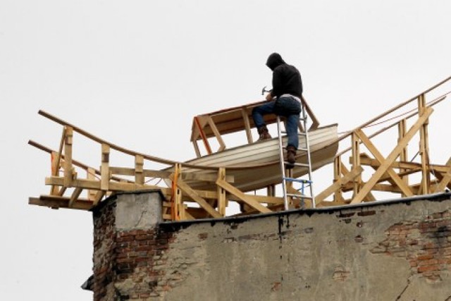 Na dachu jednej z kamienic przy rondzie Giedroycia artysta buduje łódź