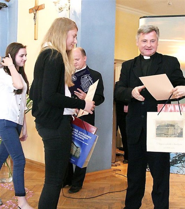 Laureatki Karolina Grudewicz i Justyna Turska (z lewej) z Gimnazjum nr 8 we Włocławku odbierają nagrody z rąk ks. Jacka Kędzierskiego, dyrektora Zespołu Szkół Katolickich.