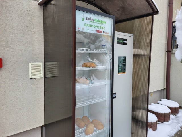 Lodówka i szafka na suche produkty stoi przed głównym wejściem do budynku Ośrodka Pomocy Społecznej przy ulicy Słowackiego 17a.