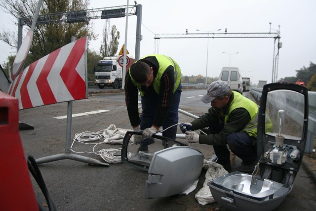 Ariel Chlebowski (z lewej) i Radosław Bykowski z firmy "Progres" montują
lampy oświetleniowe.