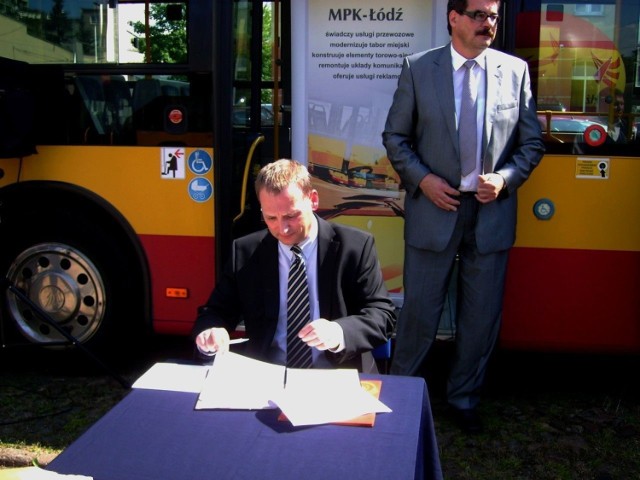 Johannes Lehmann, prezes EvoBus Polska podpisuje umowę na dostawę nowych autobus&oacute;w. Za nim Stanisław Galia, prezes MPK Ł&oacute;dź.