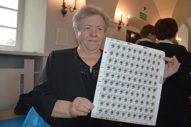 Danuta Wojda ze znaczkami, na których umieszczono oklejankę z jej wycinanką