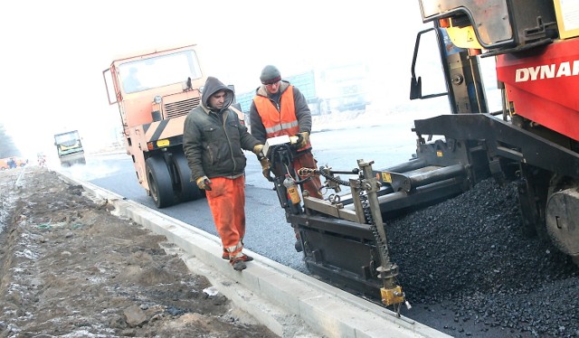 Robert Piątkowski (z lewej) i Jaromir Marczewski nadzorują układanie asfaltu.