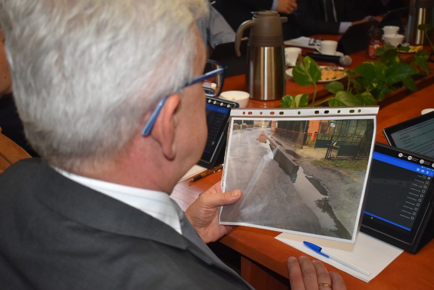 Jerzy Lisiak prezentował zdjęcie chodnika i przystanku swoim kolegom z rady. Fotografii przygląda się Bartłomiej Rogala