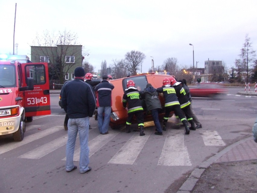 Strażacy i przechodnie podczas akcji stawiania pandy na...