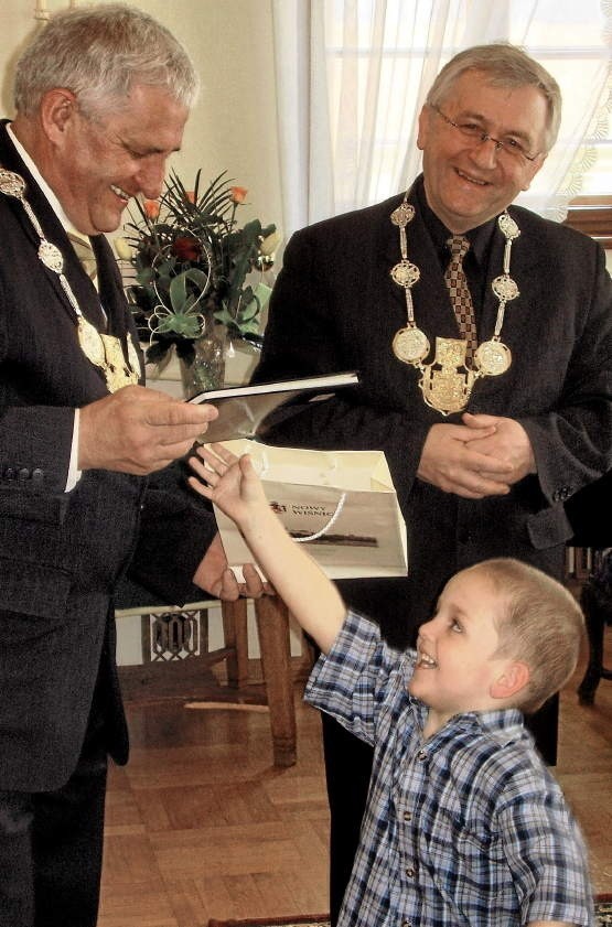 Mały Karol wyrywa się, by odebrać książeczkę od Jerzego Łacnego z władz Wiśnicza