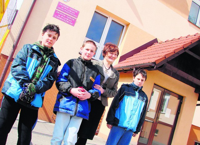 Bartosz i Jakub Majdak oraz Dominik Wądolny z dyrektorką Jolantą Kozłowską przed szkołą