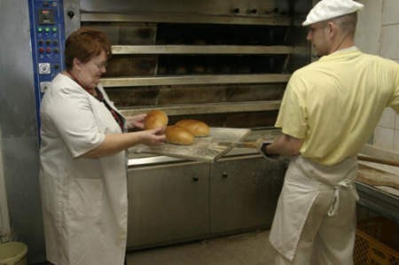 Teresa Gryc i Adam Golba sprawdzają, czy chleby są upieczone.