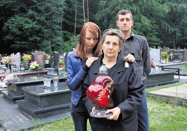 Lucyna Piątek, wdowa po Janie, z synem i wnuczką przyszli zapalić znicz na grobie na cmentarzu w Jaroszowcu