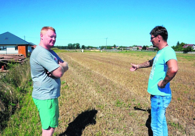 Piotr Pawelczyk (z lewej) oraz Błażej Adamus pokazują teren, na którym w gminnych planach została wyznaczona droga. Póki co jest tutaj szczere pole.