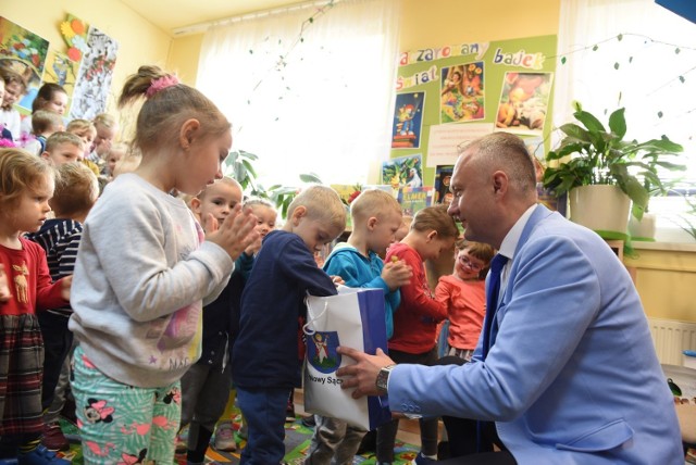 Prezydent Ludomir Handzel częstuje dzieci cukierkami podczas spotkania w bibliotece
