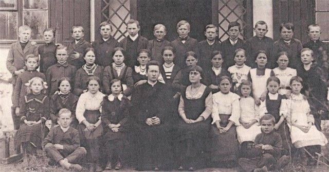 Uczniowie szkoły ludowej, jednoklasowej, pospolitej, mieszanej w Gomulinie. Fotografia pochodzi z ok.  1917 roku. Józef Kacperski stoi szósty od prawej w górnym rzędzie