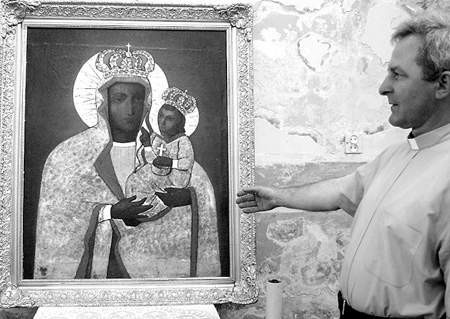 Proboszcz Edward Darłak prezentuje obraz sosnowieckiej Maryi.