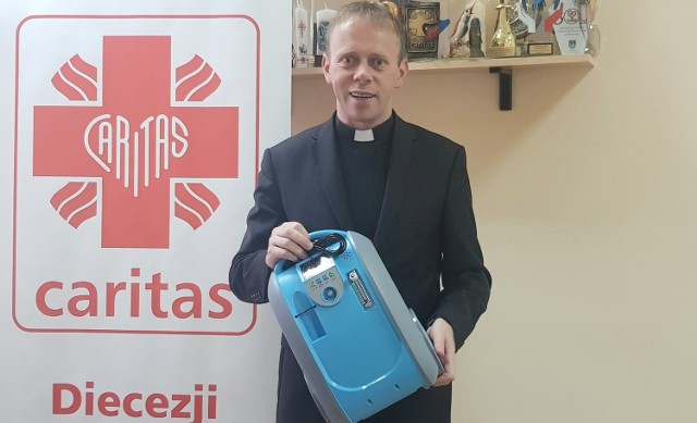 Ks. dr Piotr Potyrała, dyrektor Caritas Diecezji Rzeszowskiej, prezentuje koncentrator tlenu, który można wypożyczyć do domu.