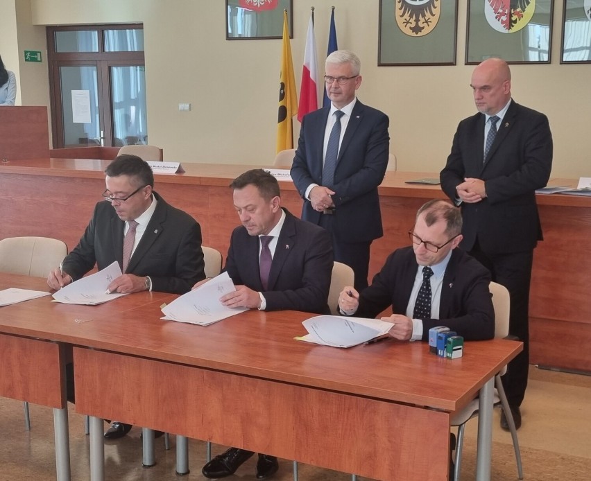 Burmistrz Nowej Rudy Tomasz Kiliński (w środku) podpisujący...