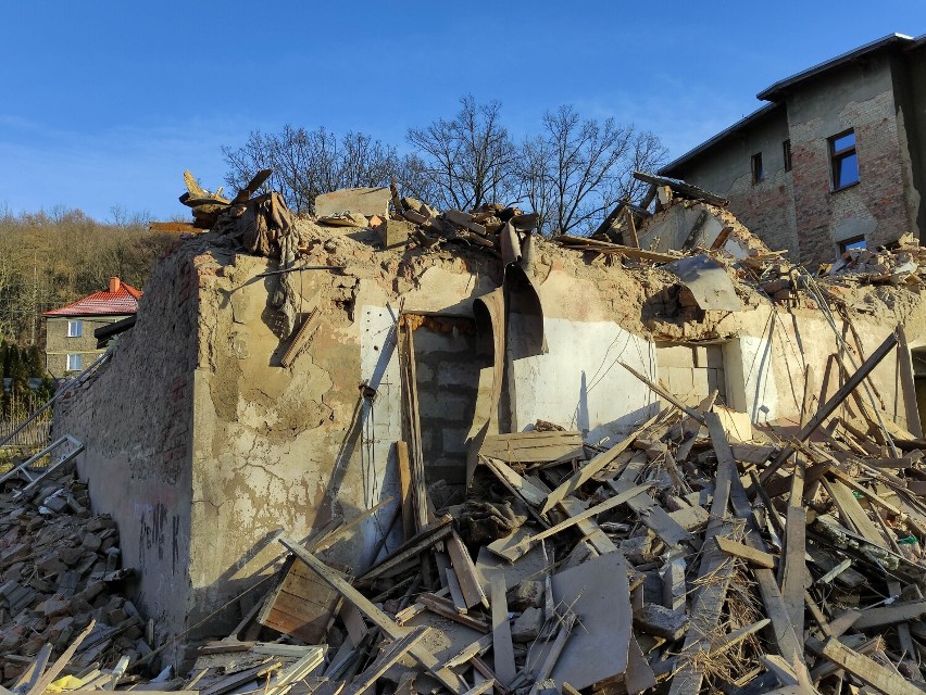 Resztki gruzu i drewna piętrzą się na placu rozbiórki.