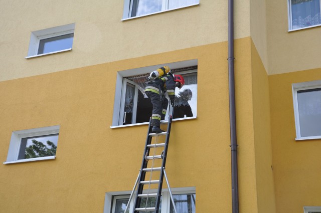 Strażacy za pomocą drabina i wchodząc przez okno dostali się do mieszkania