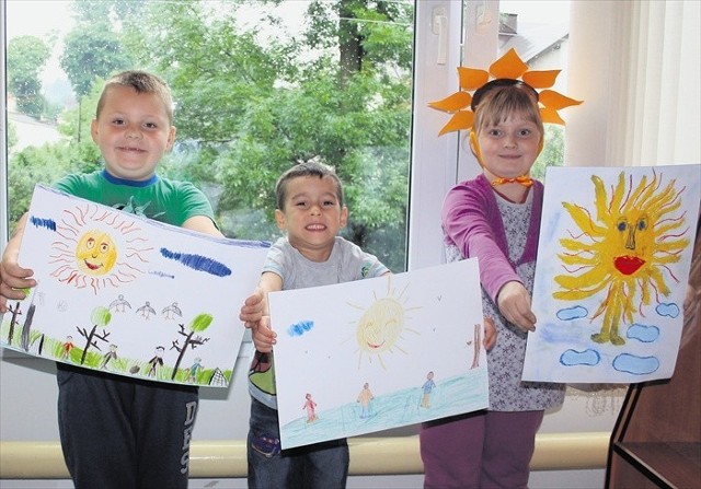 Ewa, Kuba, Kamil i Kasia z ochotą narysowali wielkie żółte słońca i proszą, by wreszcie wyjrzało do nas zza chmur